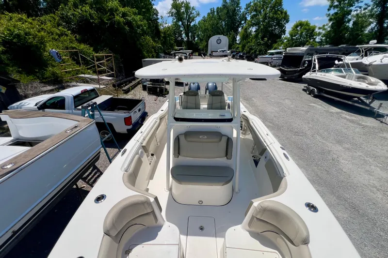 Slide: The Image of 2023 Key West 263 FS boat with spacious seating, parked among other boats and vehicles. - 17