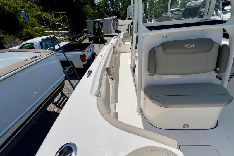 Slide: The Image of 2023 Key West 263 FS boat interior with seating and storage, parked outdoors. - 18