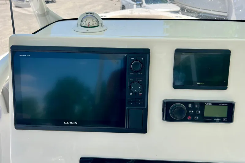 Slide: The Image of 2023 Key West 263 FS boat dashboard with Garmin GPS, Yamaha display, and Fusion audio controls. - 26