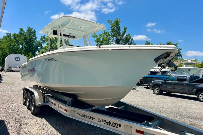 Slide: The Image of 2023 Key West 263 FS boat on trailer under clear blue sky. - 4