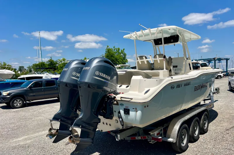 Slide: The Image of 2023 Key West 263 FS boat with dual Yamaha engines on a trailer, parked outdoors. - 6
