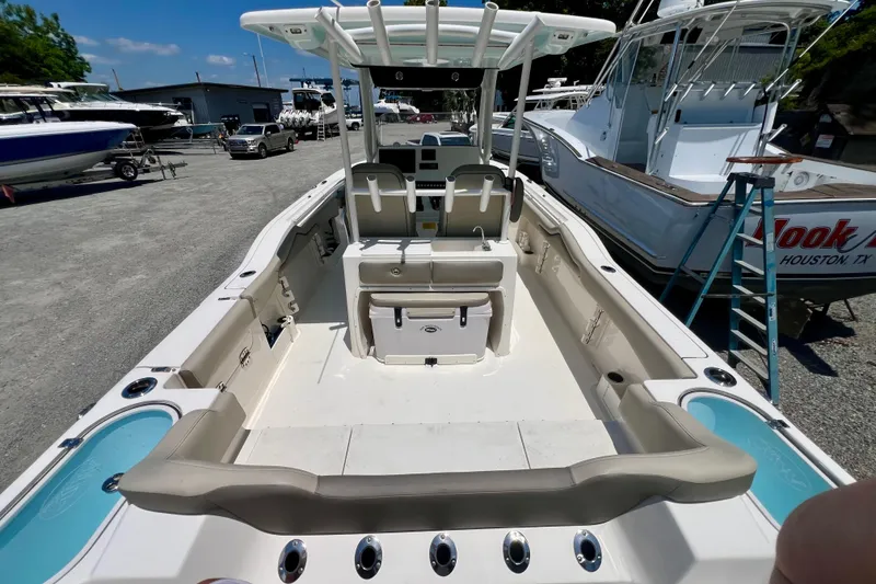 Slide: The Image of 2023 Key West 263 FS boat interior with seating and storage, docked in a marina. - 8