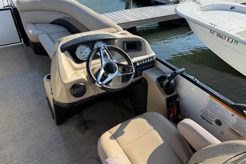 Slide: The Image of 2021 Barletta C22QC boat interior with steering wheel and dashboard controls. - 10
