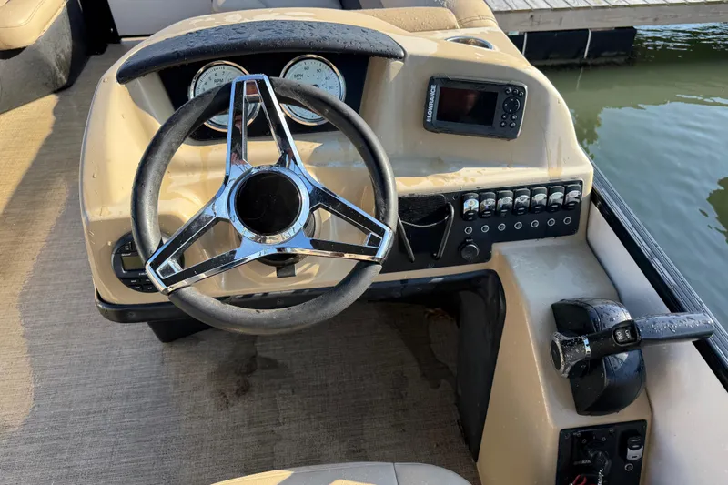 Slide: The Image of 2021 Barletta C22QC boat dashboard with steering wheel and control panel. - 11