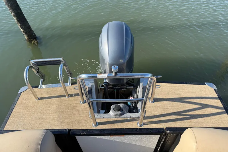 Slide: The Image of 2021 Barletta C22QC boat with outboard motor and swim ladder on calm water. - 13
