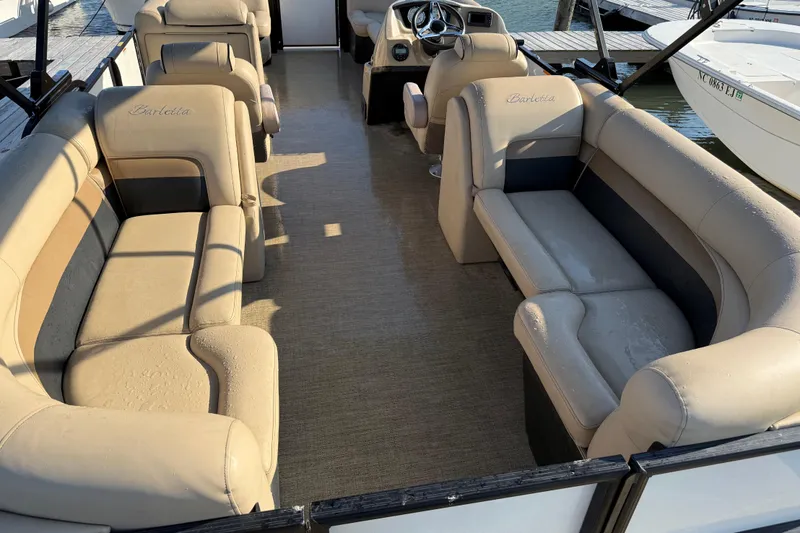 Slide: The Image of 2021 Barletta C22QC pontoon boat interior with beige seating and steering console. - 15