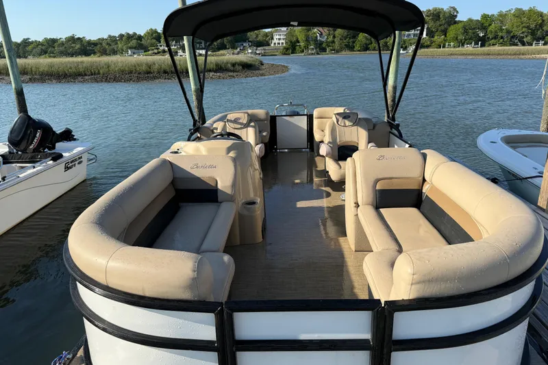 Slide: The Image of 2021 Barletta C22QC pontoon boat with beige seating, docked on a serene lake. - 3