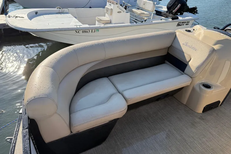Slide: The Image of 2021 Barletta C22QC boat with beige seating, docked near water. - 5