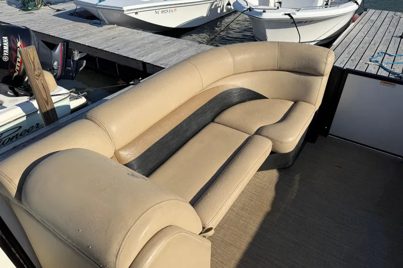 Slide: The Image of 2021 Barletta C22QC boat with beige seating, docked near other boats. - 6