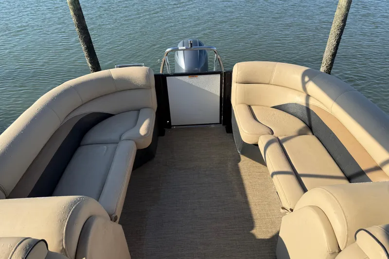 Slide: The Image of 2021 Barletta C22QC pontoon boat interior with beige seating, on calm water. - 9