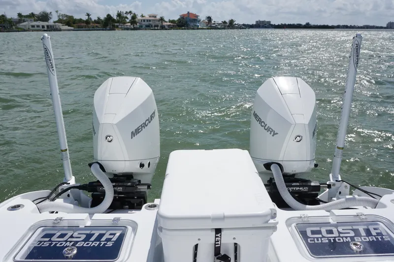 Slide: The Image of 2024 Costa Custom Boats 264HC with dual Mercury engines on a sunny day. - 18