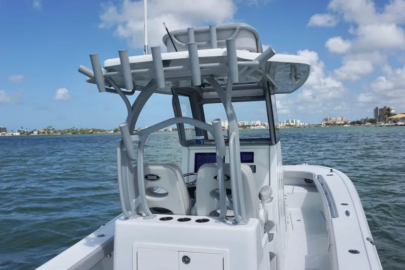 Slide: The Image of 2024 Costa Custom Boats 264HC on water, showcasing helm and seating under clear blue sky. - 19