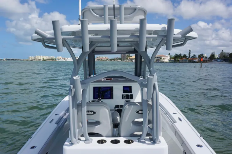 Slide: The Image of 2024 Costa Custom Boats 264HC on water, featuring helm and rod holders under blue sky. - 20