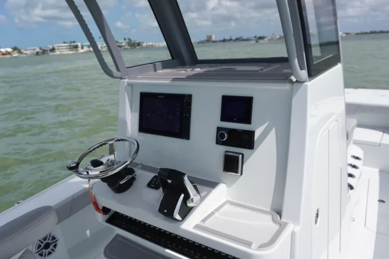 Slide: The Image of 2024 Costa Custom Boats 264HC helm with modern controls and navigation screens on open water. - 22