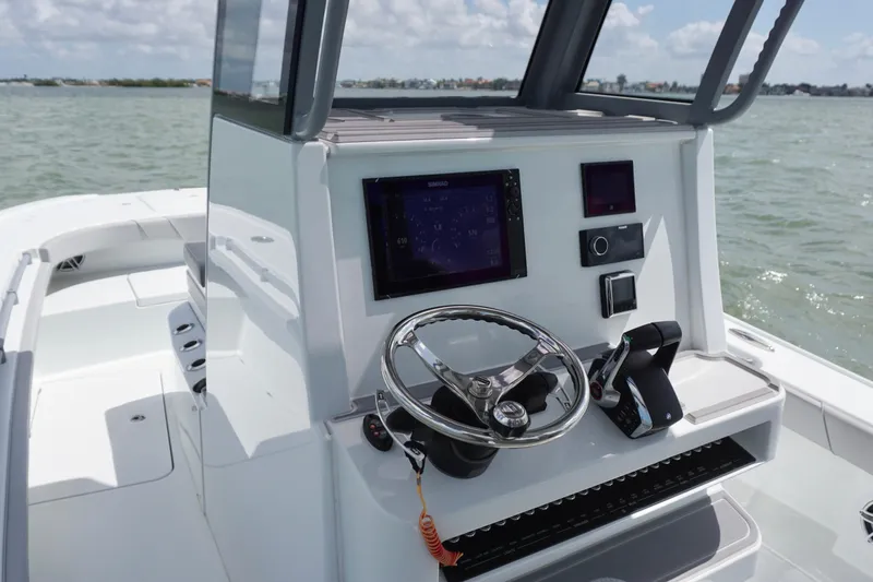 Slide: The Image of 2024 Costa Custom Boats 264HC helm with modern controls and navigation system on open water. - 24