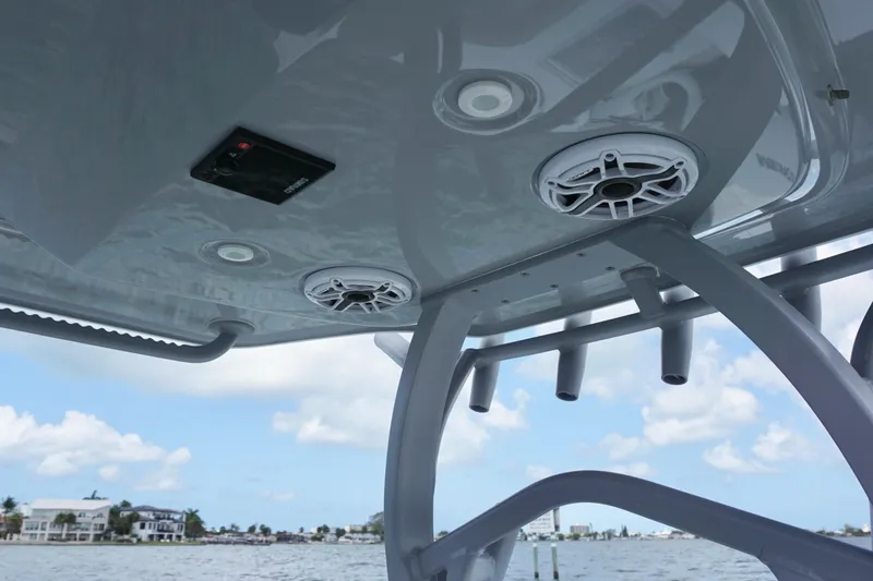 Slide: The Image of 2024 Costa Custom Boats 264HC with speakers and rod holders, under a clear blue sky. - 25