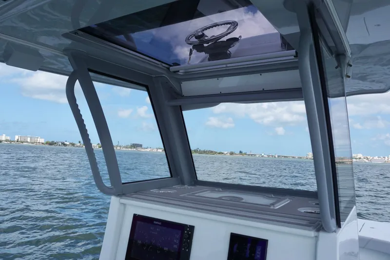 Slide: The Image of 2024 Costa Custom Boats 264HC helm view with ocean backdrop and clear skies. - 26