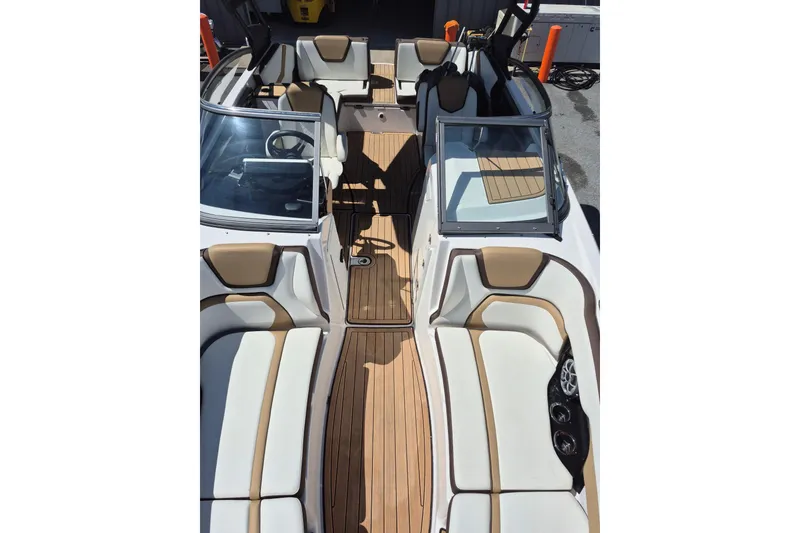 Slide: The Image of 2021 Yamaha Boats 252SE interior with tan seating and wood-style flooring. - 11