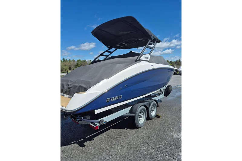 Slide: The Image of 2021 Yamaha Boats 252SE on trailer, covered, under clear blue sky. - 3