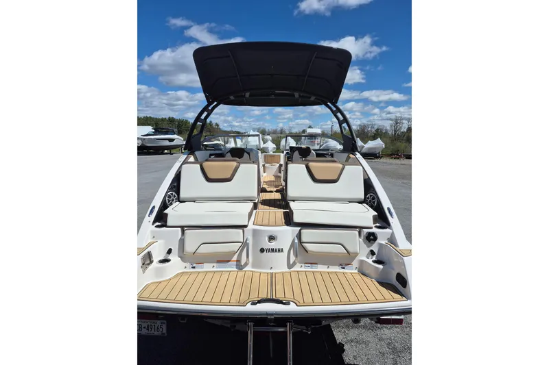 Slide: The Image of 2021 Yamaha Boats 252SE with sleek seating and modern design under a clear blue sky. - 5