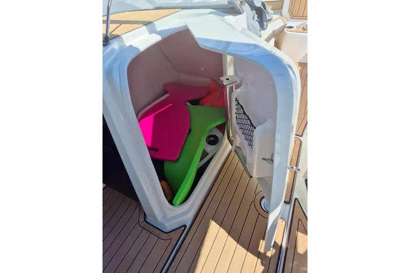 Slide: The Image of 2021 Yamaha Boats 252SE storage compartment with colorful floatation devices. - 8