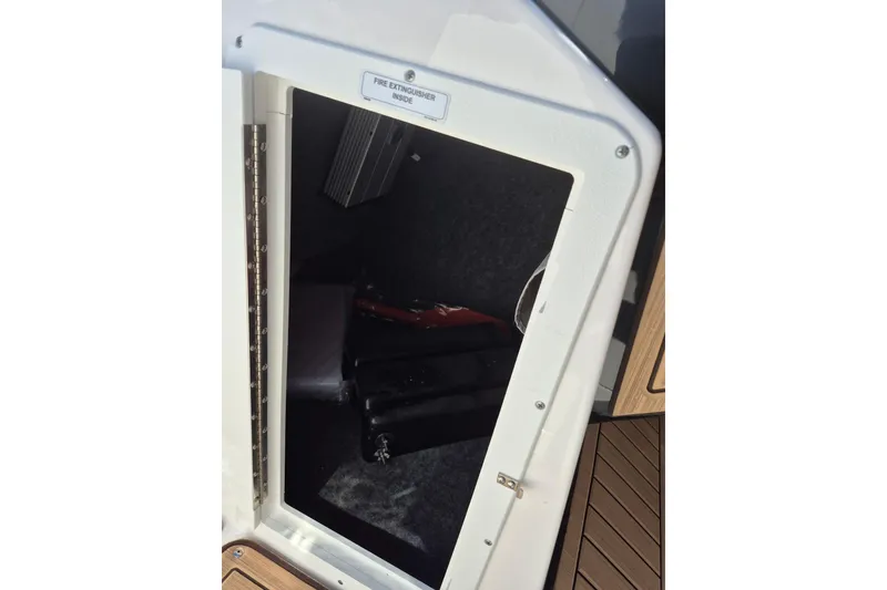 Slide: The Image of 2021 Yamaha Boats 252SE storage compartment with fire extinguisher inside. - 9