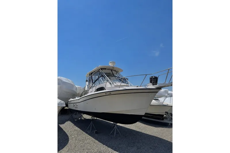 The Image of 2003 Grady-White Sailfish 282 boat on stands under clear blue sky. - 0