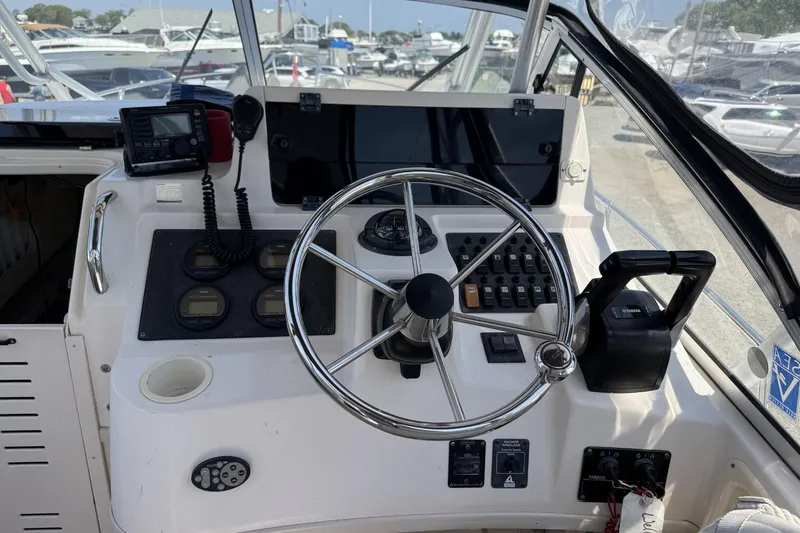 Slide: The Image of 2003 Grady-White Sailfish 282 boat helm with steering wheel and navigation controls. - 11