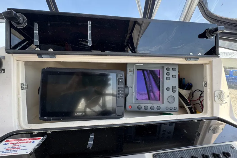 Slide: The Image of 2003 Grady-White Sailfish 282 dashboard with Garmin and Raymarine navigation systems. - 12