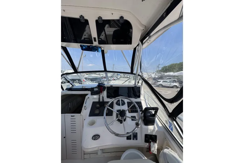 Slide: The Image of 2003 Grady-White Sailfish 282 boat cockpit with steering wheel and navigation equipment. - 13