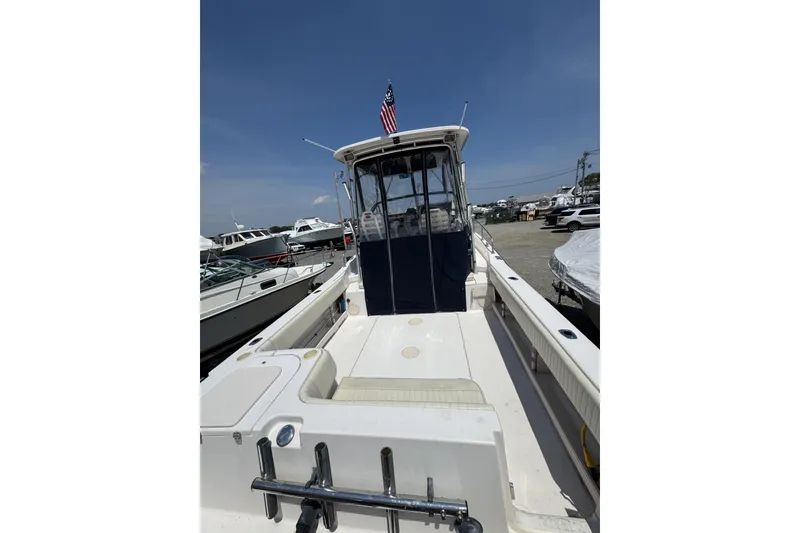 Slide: The Image of 2003 Grady-White Sailfish 282 boat with American flag, docked under clear sky. - 22