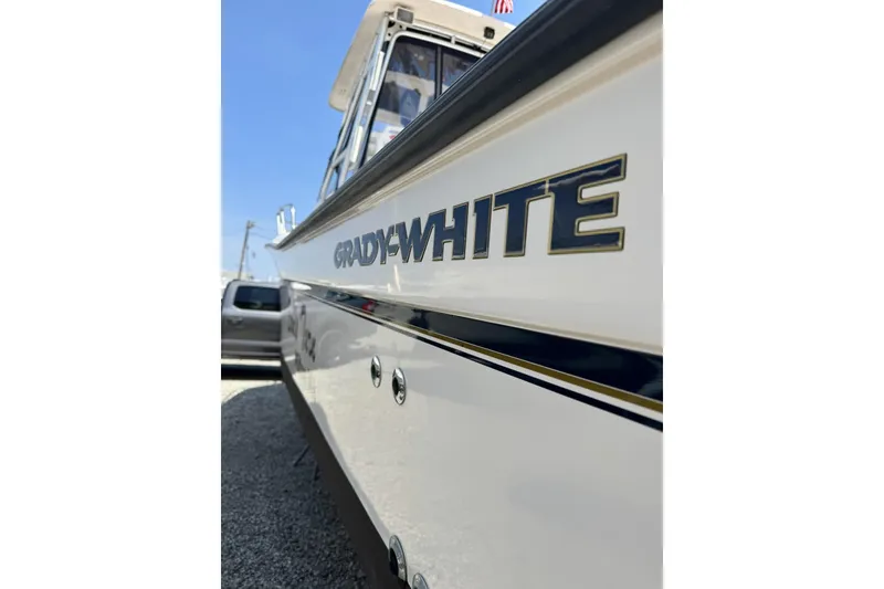 Slide: The Image of 2003 Grady-White Sailfish 282 boat side view with logo, parked outdoors. - 3