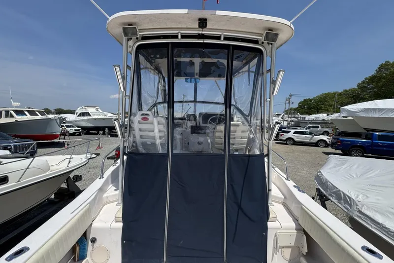 Slide: The Image of 2003 Grady-White Sailfish 282 boat with enclosed cockpit, parked among other boats. - 6