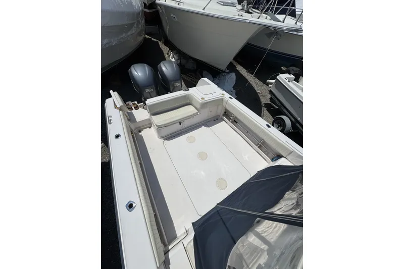 Slide: The Image of 2003 Grady-White Sailfish 282 boat deck with twin outboard engines, docked in a marina. - 7