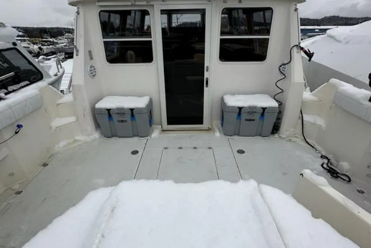 Slide: The Image of Snow-covered deck of a 2000 SeaSport Pacific 3200 boat in a marina. - 13