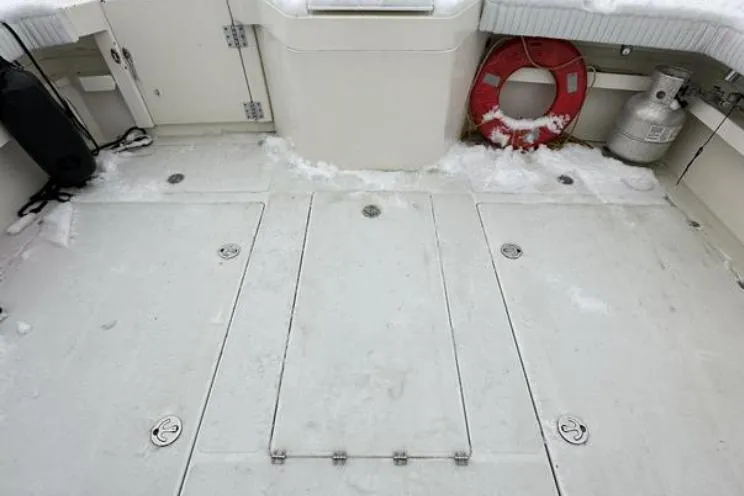 Slide: The Image of Snow-covered deck of a 2000 SeaSport Pacific 3200 boat with safety equipment. - 14
