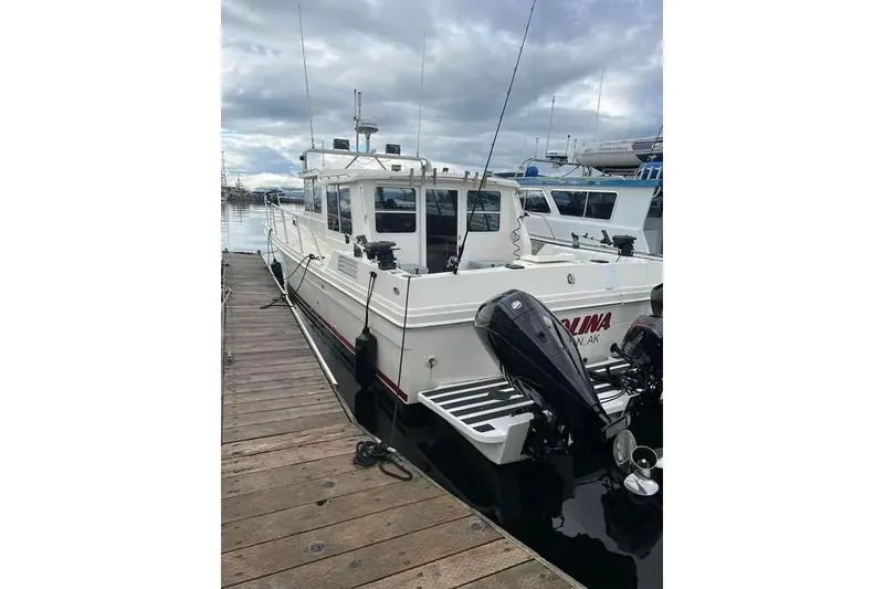 Slide: The Image of 2001 SeaSport Pacific 3200 boat docked at marina with outboard motors. - 16