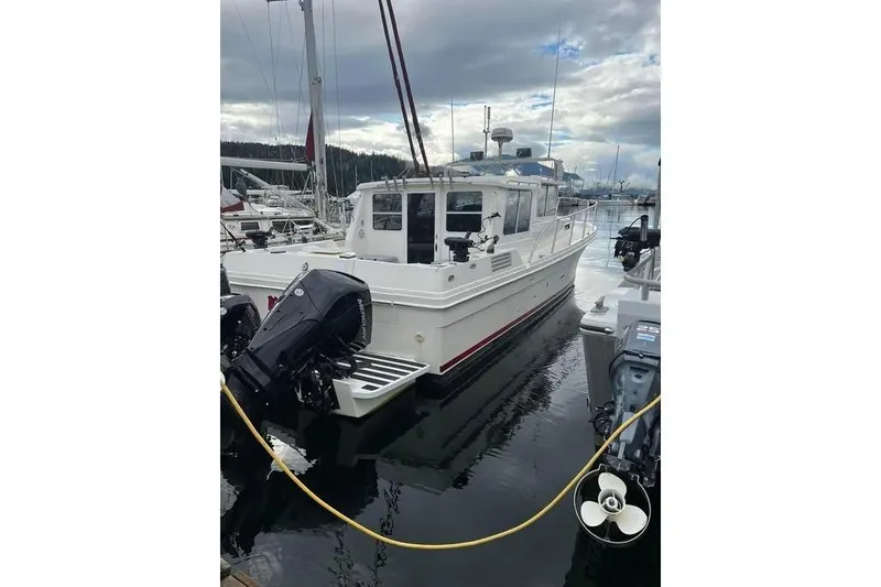 Slide: The Image of 2001 SeaSport Pacific 3200 boat docked in a marina, featuring dual outboard motors. - 17