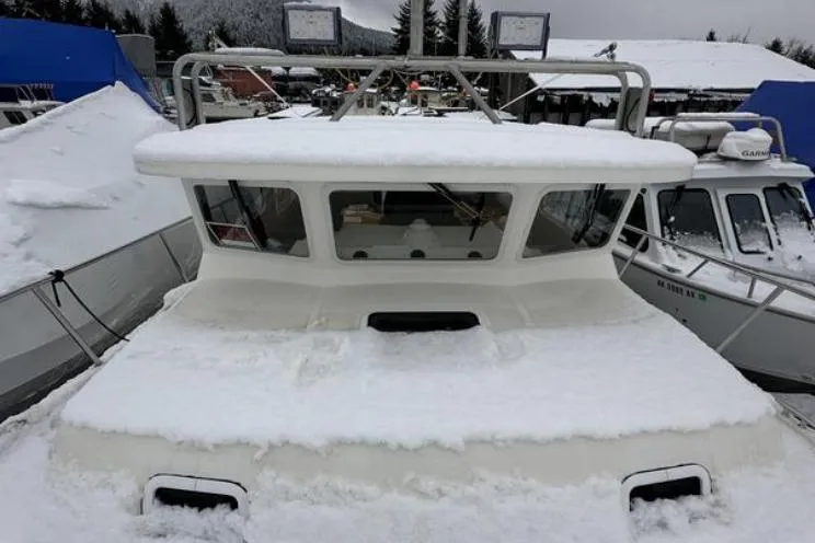 Slide: The Image of SeaSport Pacific 3200 boat covered in snow, docked in a winter marina. - 23