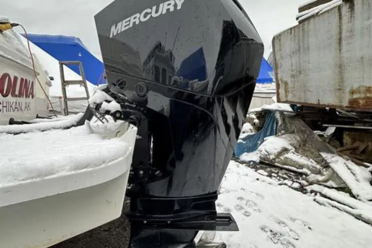 Slide: The Image of Snow-covered SeaSport Pacific 3200 boat with Mercury outboard motor, 2000 model, in a snowy setting. - 24
