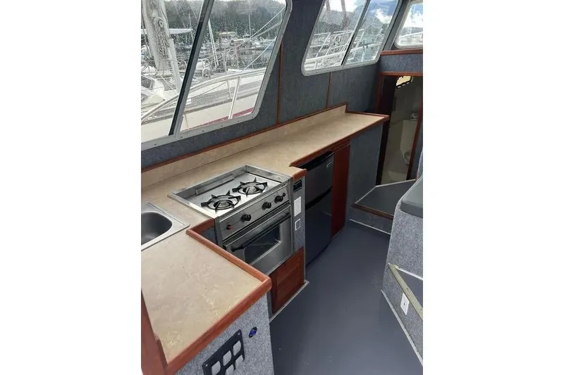 Slide: The Image of Interior of 2001 SeaSport Pacific 3200 boat featuring a compact kitchen area. - 3