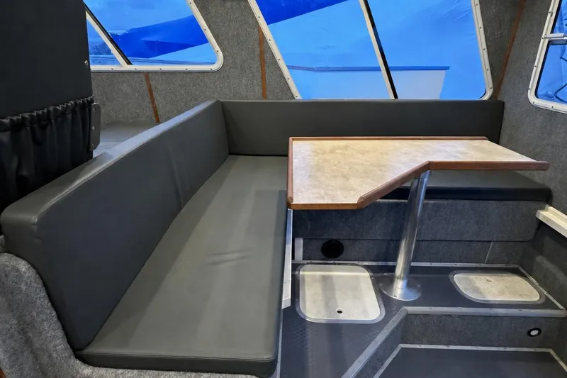 Slide: The Image of Interior of a 2000 SeaSport Pacific 3200 boat with a cozy seating area and table. - 5