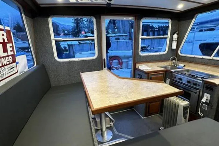 Slide: The Image of Interior of 2000 SeaSport Pacific 3200 boat with dining area and kitchen amenities. - 7