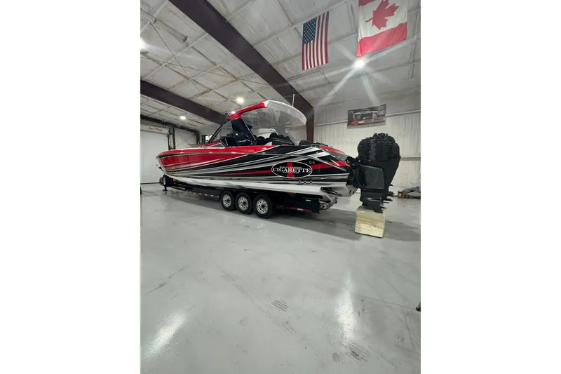 Slide: The Image of 2021 Cigarette 41' Nighthawk boat in a garage, featuring sleek red and black design. - 3