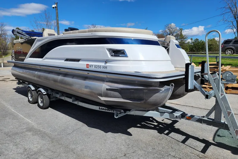 Slide: The Image of 2022 Silver Wave 2410 SW5 pontoon boat on trailer under clear blue sky. - 4