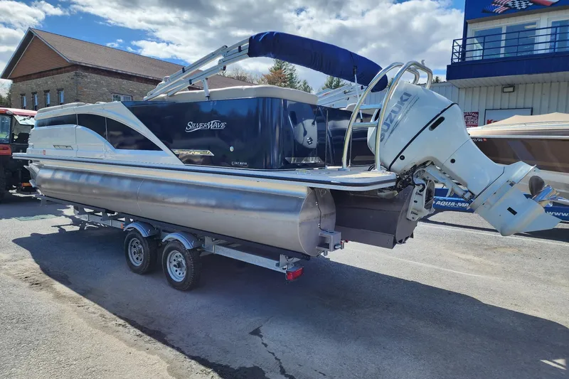 Slide: The Image of 2022 Silver Wave 2410 SW5 pontoon boat on trailer, featuring Suzuki outboard motor. - 6