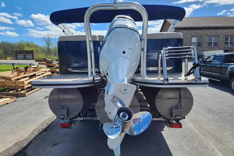 Slide: The Image of 2022 Silver Wave 2410 SW5 pontoon boat with outboard motor, parked outdoors. - 7