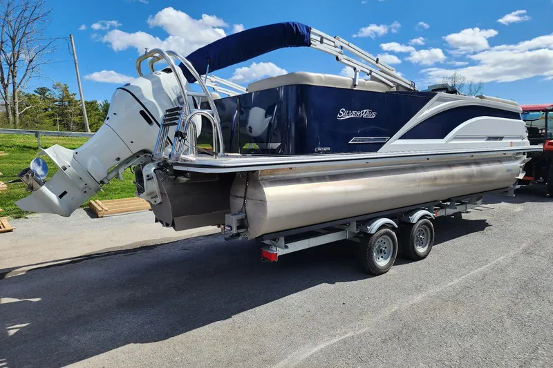Slide: The Image of 2022 Silver Wave 2410 SW5 pontoon boat on trailer under blue sky. - 8