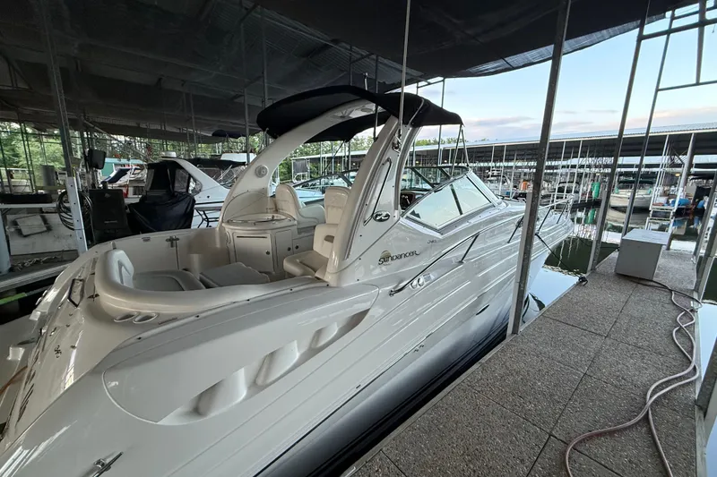 Slide: The Image of 2003 Sea Ray 340 Sundancer docked in a marina, showcasing sleek design and luxury features. - 2