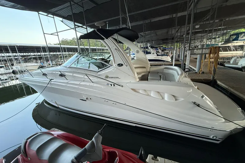 Slide: The Image of 2003 Sea Ray 340 Sundancer docked in a marina, showcasing sleek design and luxury features. - 4